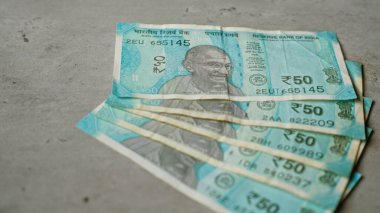 Hindistan 'ın somut bir yüzey üzerindeki banknotları, Hindistan' ın 50 rupilik bankasında Gandhi 'nin portresini gösteren belirgin detaylarla vurgulandı..