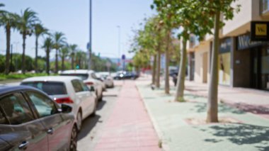 Park halindeki arabalarla, bulanık ağaçlarla ve güneşli bir günde odandan çıkmış bir arka planla açık şehir manzarası.