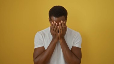 Sarı arka plana bakan genç adam duygu ve tefekkür gösteriyor, yalnızlığı ve içselliği parlak bir kontrastla vurguluyor..