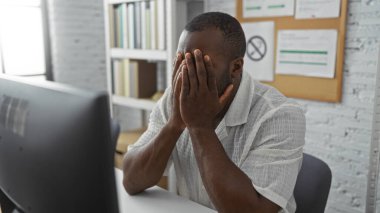 Ofisteki genç adam masasında otururken gergin görünüyor.