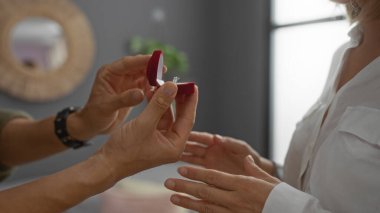 Erkek, gün içinde kırmızı kutuda nişan yüzüğüyle kadına evlenme teklif ediyor.