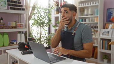 Bir dükkânda çalışan İspanyol asıllı genç adam dizüstü bilgisayar ekranına bakarken şaşırdı ve beklenmedik haberler vermeye başladı.