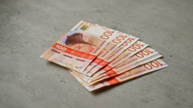 Somut arkaplan üzerindeki Norveç kroneri banknotları mali zenginlik ve para birimi değeri portrelerini belirtir.
