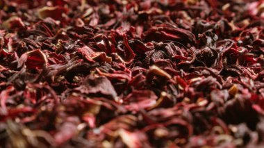 Yakın planda kurumuş amber yaprağı canlı kırmızı ve koyu renkli dokulu bir yüzey oluşturuyor.