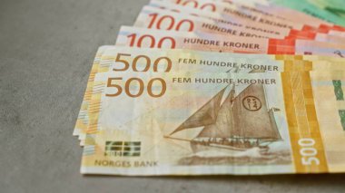 Beton yüzey üzerine Norveç banknotları 500 ve 100 'lük banknotlar içeren renkli kron banknotlar sergiliyor.