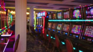 Bulanık renkli kumar makineleri Las Vegas 'ta loş bir kumarhane hizasında neon ışıkları canlı bir atmosfer yaratıyor..