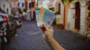 Bir şehir caddesinde el ele tutuşan Malezya halkaları canlı bir açık şehir ortamında para ve iş unsurlarını yakalıyor..