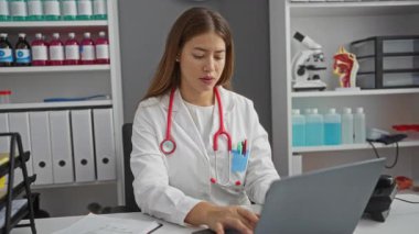 Üniformalı genç bayan doktor, klinik randevusuna geç kaldığı için endişe içinde nöbete bakıyor.