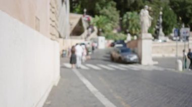 Roma, İtalya 'daki Piazza del Popolo' nun odak alanı dışında güneşli açık hava koşulları altında bulanık insanlar, sokak ve bokeh etkisi.