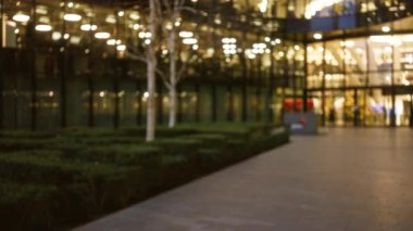 Gece vakti Londra caddesinin bulanık görüntüsü cam ve kaldırıma yansıyan Bokeh ışıkları atmosferik kış manzarası yaratıyor..