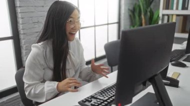 Modern ofis ortamında bir video konferansında anahtar tutan kadın, gözlük takıyor ve gülümsüyor, iletişimi, gayrimenkul ve profesyonel başarıyı temsil ediyor..