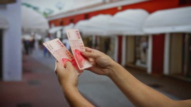 Kentsel bir caddede para sayan eller finansal yatırımlar ve açık hava ticareti sergileniyor..