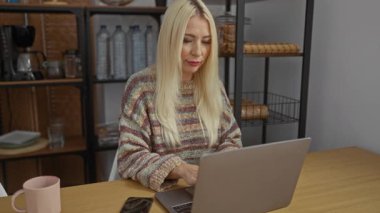 Evde dizüstü bilgisayarda çalışan bir kadın rahat oturma odasında rahat bir dekor ve modern teknolojiyle rahat bir yaşam tarzı dengesi kuruyor..