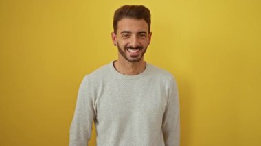 Genç adam gülümsüyor ve arabanın anahtarlarını canlı sarı bir arka planda tutuyor, heyecanla kutluyor..