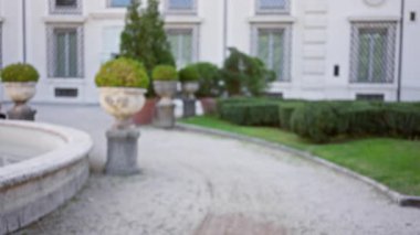 Bulanık görüntü, İtalya 'da yeşillik, tarihi yapı cephesi ve dekoratif vazolarla birlikte villa borghese' deki bir avluyu gösteriyor..