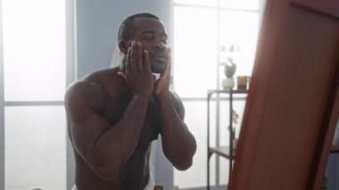 Sağlık tedavisinin keyfini çıkarırken kaplıca odasında yüzüne hafifçe dokunan genç bir adam.