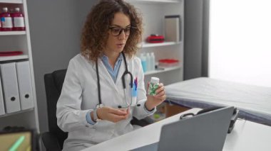 Steteskoplu kadın doktor, tıbbi muayenehanedeki video görüşmesi yoluyla ilaçları tartışıyor, eczacılıkla profesyonel sağlık hizmetleri sunuyor.