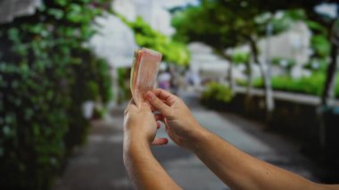 Aydınlık bir günde, sokak gösterisinde Filipinli pezoları sayan bir adam açık havada iş ve yatırım yapıyor..