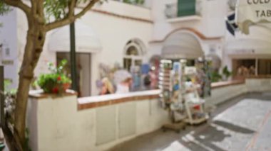 Capri caddesinde kadın ve turist dükkanlarının bulunduğu bulanık manzara, İtalya 'da güneş ışığı ve Avrupa mimarisi ile dağılmış lüks bir ada atmosferi yakalıyor..