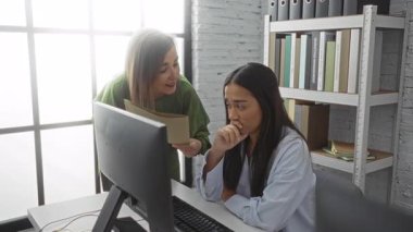 Modern ofiste kadın meslektaşımla belgeleri tartışan bir kadın.