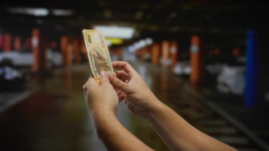 Kentsel park alanında Norveç banknotları sayan bir adam, mali işlemleri ve yatırım temalarını vurguluyor.