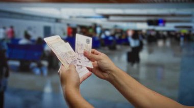 Havaalanı terminalinde tek başına dolar sayan adam, para değişimi ve ticari işlemlere odaklı seyahat finans ve yatırım sergiliyor..