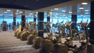 Spor salonundaki insanların spor salonlarında yaptıkları bulanık sahne, Bokeh ışıklandırmasıyla odak dışı bir etki yaratıyor..