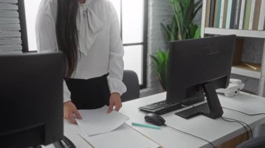 Ofiste elinde bilgisayar ve fabrikalarla çevrili, profesyonelliği ve modern çalışmayı yansıtan parlak kapalı bir ortamda duran bir kadın..