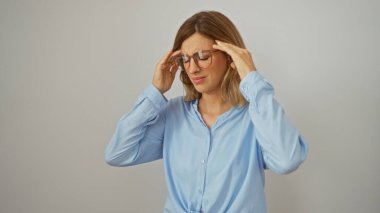 Hüsrana uğramış mavi gömlekli sarışın kadın izole edilmiş beyaz arka plan yüzünden baş ağrısı çekiyor.