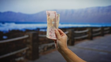 Şehir manzaralı bir sahile karşı el ele tutuşmak, finans ve seyahat temalarını vurgulamak, şehir manzaralı bir plaj..