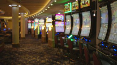 Las Vegas kumarhanesinin bulanık görüntüsü canlı kumar makineleri ve loş aydınlatmalı iç mekanları, canlı ambiyansı ve renkli ışıkları sergiliyor..