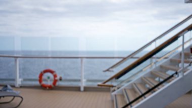 Bulanık arkaplan görüntüsü, okyanus manzarası, ahşap merdivenler ve güvenlik çemberine odaklanmış lüks bir gezi güvertesini gösteriyor..