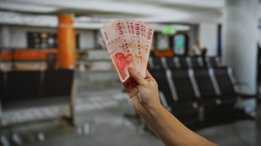 Havaalanı terminalinde el ele tutuşan Tayvan doları iş ve yatırım senaryoları arasında seyahat ve finans bağlamlarını vurguluyor.