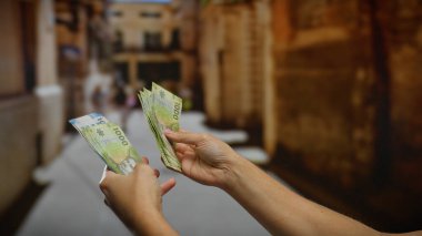 Şehir caddesinde elinde Şili pezosu tutan bir adam, şehir merkezinde yatırım ya da iş anlaşması öneriyor..