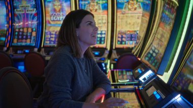 Las Vegas kumarhanesinde kumar oynayan bir kadın hareketli bir gecede renkli iç mekanlar ve parlak ışıklar sergiliyor..