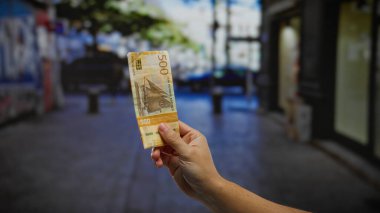 Kentsel caddede Norveç kronu ile el ele tutuşmak, şehir çevresindeki para ve ekonomik faaliyetlere odaklanarak açık hava iş ve finans yatırımlarının özünü yakalamak.