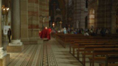 Kilisenin içini kırmızı cüppeli ve cemaatli papazla bulanıklaştırmış. Dini tören ve mimari ayrıntıları vurguluyor..