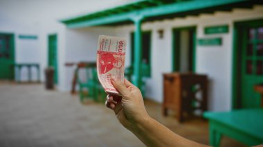 Otelin yakınındaki açık şehir ortamında el ele tutuşan İzlanda Krona banknotu, sokakta erkek varlığıyla para, yatırım ve para birimi temalarını ön plana çıkarıyor.