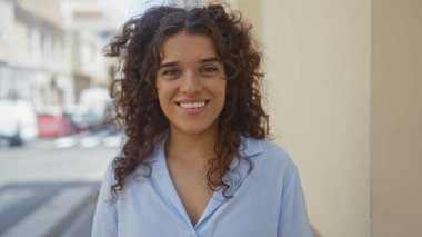 Genç, güzel, İspanyol, güneşli bir günde şehir sokağında gülümseyen bir kadın.