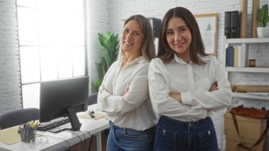 Parlak, modern bir ofiste çapraz kollara sahip kadın yöneticiler, profesyonel bir işyeri ortamında takım çalışması ve güven gösteriyorlar..