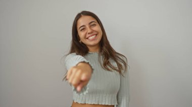 İzole edilmiş beyaz bir arka planda neşeli bir gülümseme ile işaret eden kadın, pozitiflik ve neşe göstergesi, mutluluk ve güven kavramları için ideal..
