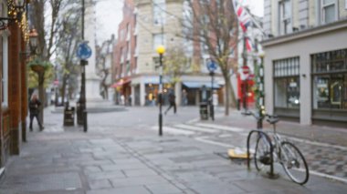 Yedi kadranlı bir kış caddesinin bulanık görüntüsü, Londra, arka planda bisikletlerin ve İngiliz bayraklarının yanındaki insanlarla birlikte bokeh efektini yakalıyor..