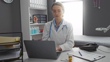 Klinikte steteskop ve tıbbi belgeleri olan bir kadın doktor..