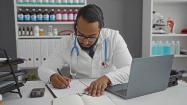 Doktor modern bir klinikte notlar yazıyor, yakınlarda tıbbi ekipman ve dizüstü bilgisayarla evrak işleriyle uğraşıyor..