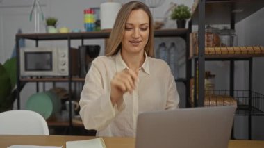 Kadın, arka planda raflar olan modern bir ofis ortamında bilgisayarını kapatırken gülümsüyor ve işten sonra memnuniyet ve rahatlama hissi veriyor..