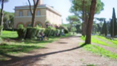 Villa borghese, Roma 'daki bulanık bahçe yolunun Bokeh manzarası, güneşli hava altında bulanık ağaçlar ve çalılıklar.