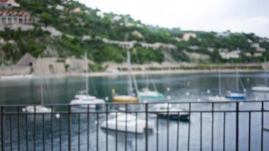 Bulanık liman manzarası. Arka planda çözünmüş botlar ve yeşillik. Korkuluklardan çekilen sakin bir kıyı limanı atmosferi yaratıyor..