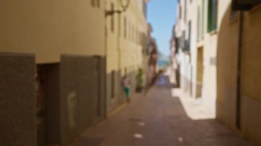 Mallorca 'da odaksız sokak manzarası. Arka planda bir kadın güneşli bir günde Bokeh kentsel manzarasını gösteriyor.