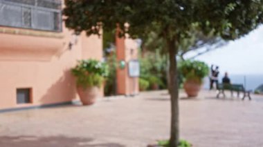 Capri 'de bulanık bir manzara. Akdeniz manzarası yakınındaki bir caddede dağılmış turistler açık gökyüzü altında lüks bir ortam yaratıyor.