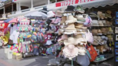Arkaplanda renkleri ve şekilleri harmanlayan canlı şapkalar ve aksesuarlarla odaksız yaz marketi
